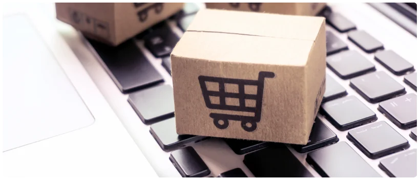Carrinho de compras minuatura em cima de teclado de notebook