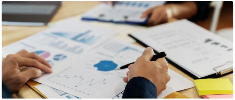 Gráficos e relatórios financeiros de uma empresa espalhados na mesa